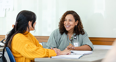 Students talking to each other at desk