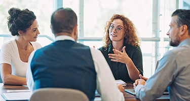 Business professionals talking at meeting table