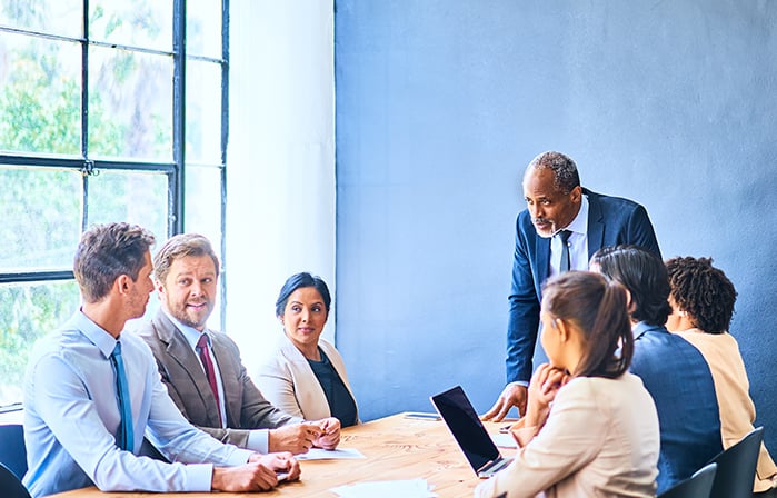 Seven business people in a meeting