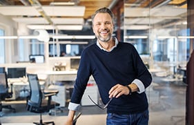 Business worker standing at desk and smiling