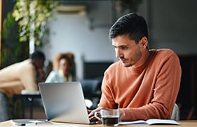 Online student working on laptop from cafe