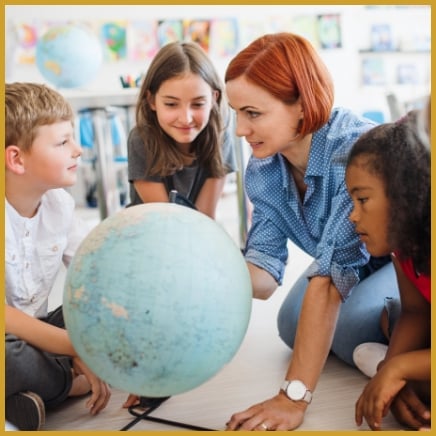 Teacher and students looking at globe together
